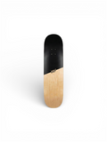 Skateboard deck with black top and wooden bottom on a white background